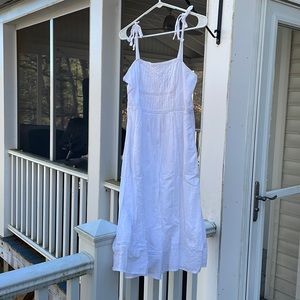White sundress with tie shoulder straps and embroidered detailing